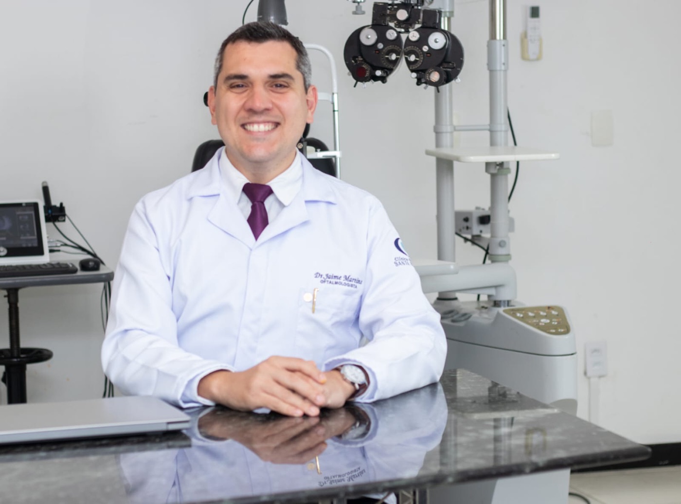 Dr. Jaime Martins ao lado de equipamento oftalmológico de diagnóstico